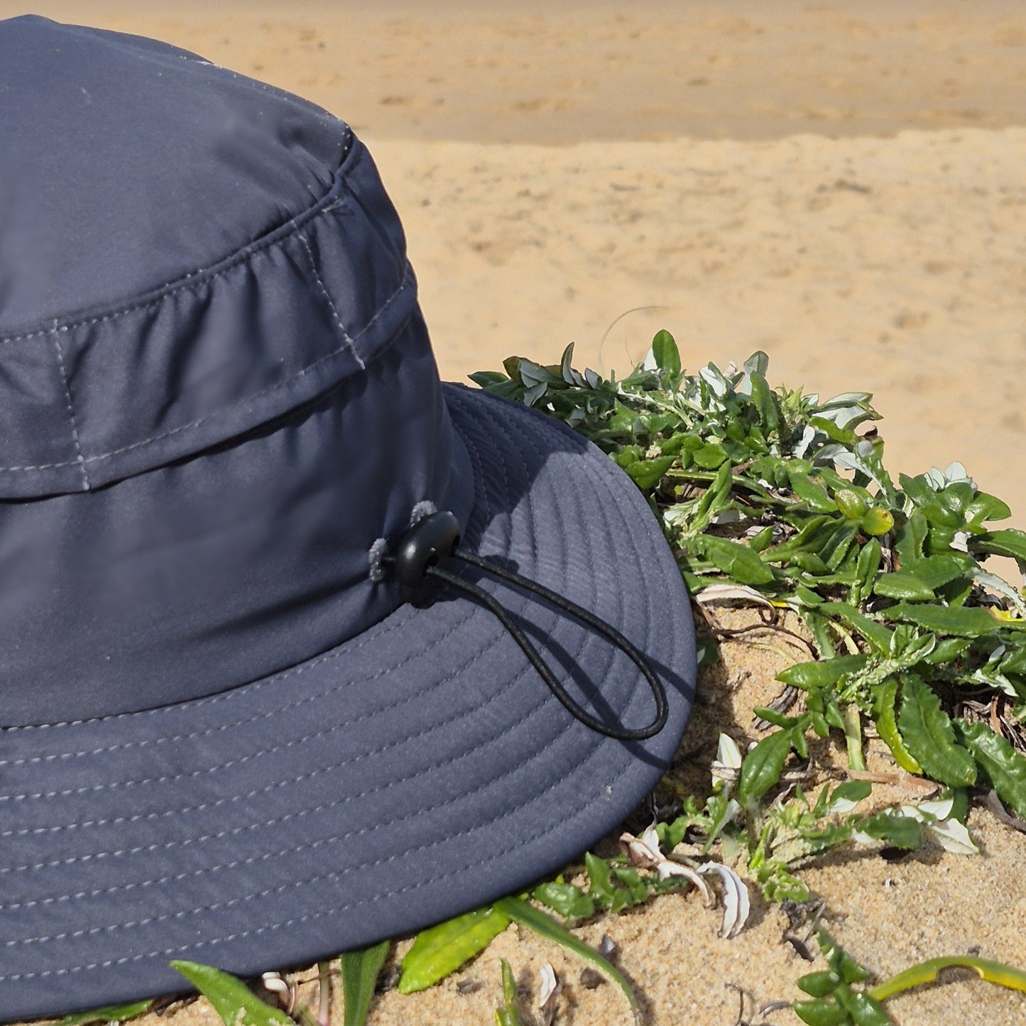 Surf hat charcoal back view, elastic adjustable strap and mesh panels for optimal waterflow