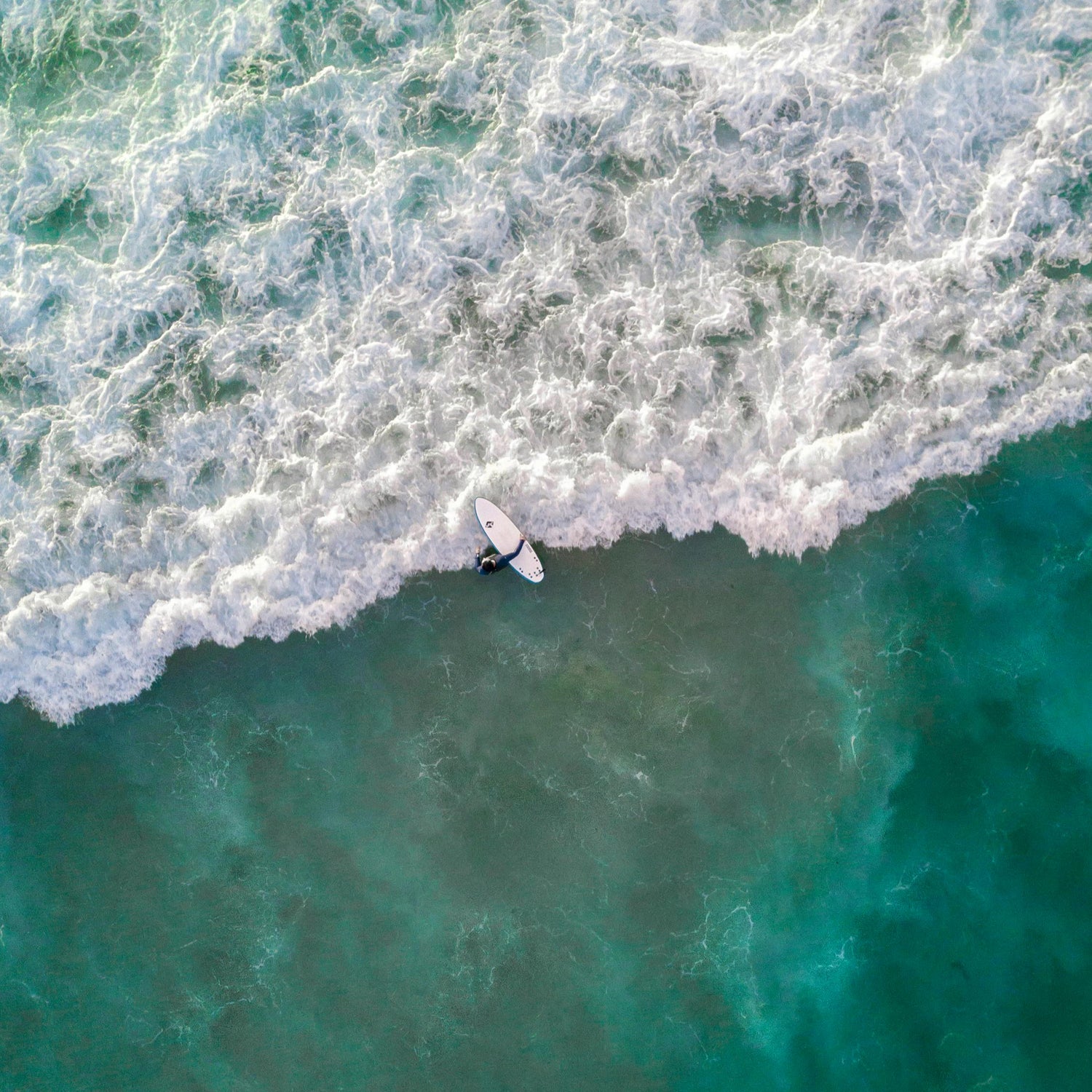 Surfer going inside the ocean on the white wash
