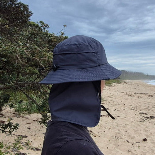 removable neck flap on a surf hat back view woman on the beach 