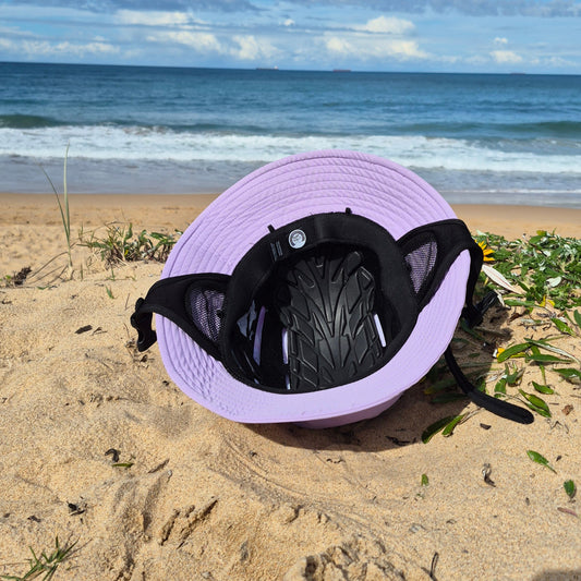 Surf hat inside view of protective insert neoprene sweatband and earmuffs with wide brim on a beach. Surf Helmet