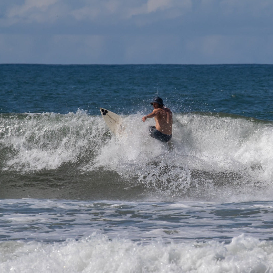 surfer wearing a surf hat helmet on a wave